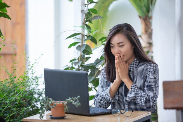 Empresaria sonriente que trabaja en la computadora portátil en café