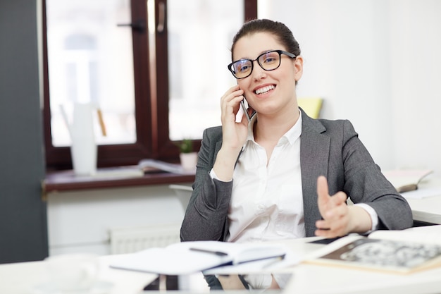 Foto gratuita empresaria sonriente con teléfono móvil