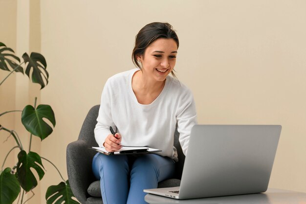 Empresaria sonriente tomando notas en un portapapeles