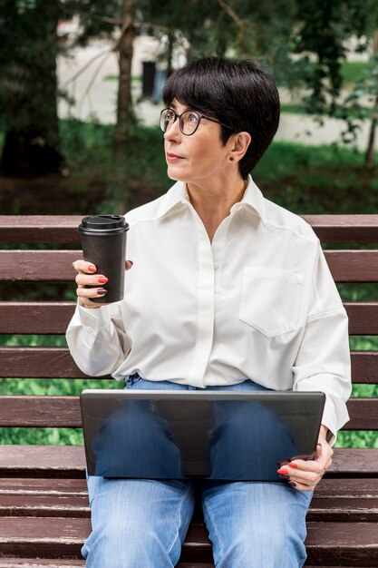 La empresaria sosteniendo una taza de café y mirando a otro lado