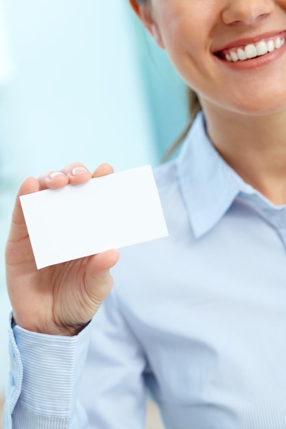 Foto gratuita empresaria sujetando una tarjeta de negocios en blanco