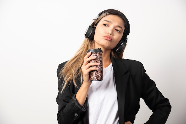 Empresaria con taza y auriculares.