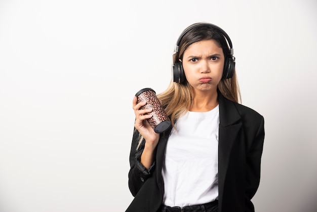 Foto gratuita empresaria con taza y auriculares.