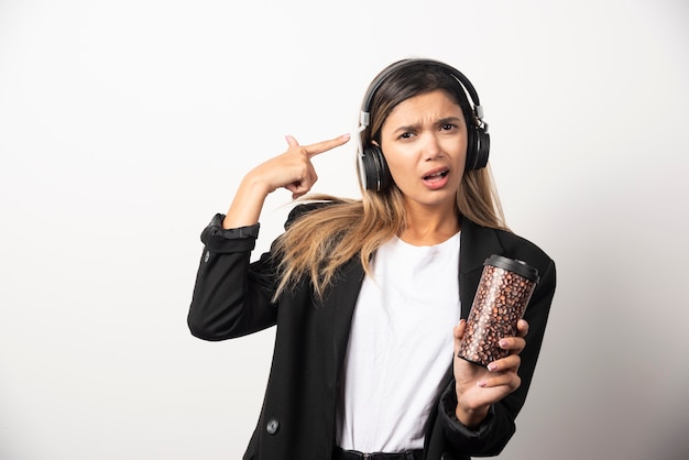 Empresaria con taza y auriculares.