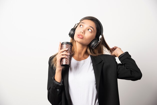 Empresaria con taza y auriculares.