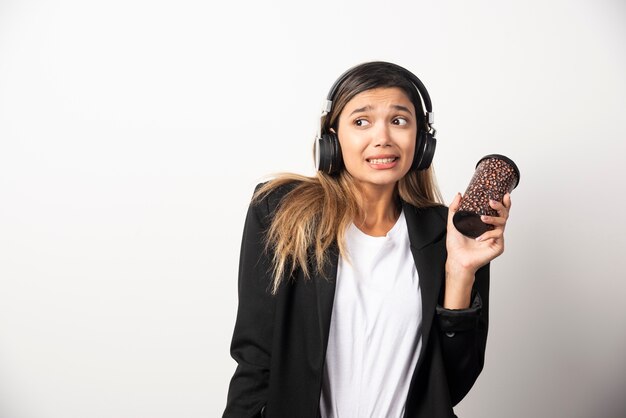 Empresaria con taza y auriculares.