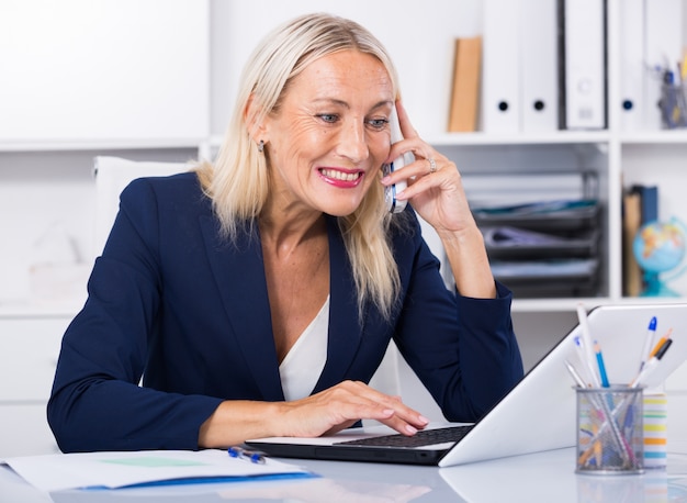 Empresaria tener conversación telefónica en la oficina