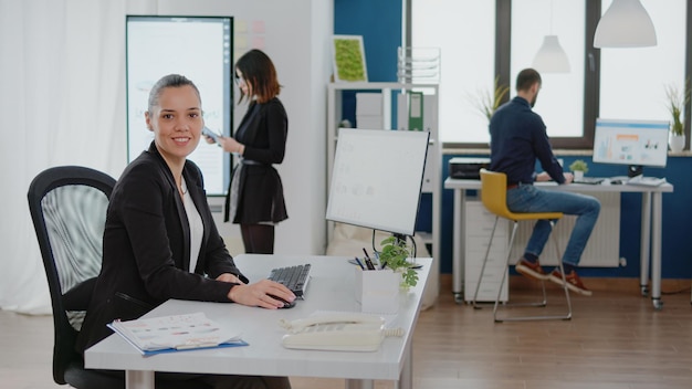 Empresaria trabajando en equipo con gráficos de datos para la estrategia de gestión en la oficina corporativa. Emprendedor con tecnología y monitor para el análisis de la investigación y la planificación del diseño.