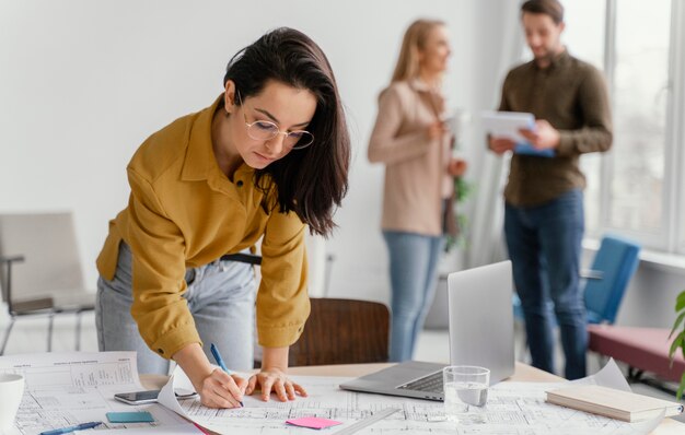 La empresaria trabajando mientras sus compañeros de equipo están hablando