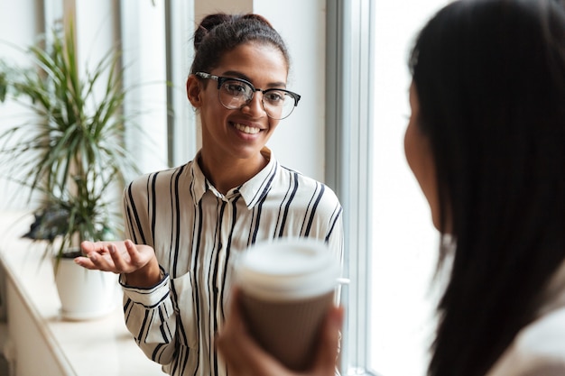 Foto gratuita empresarias colegas hablando entre sí