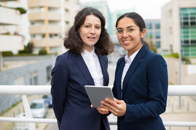 Foto gratuita empresarias de contenido con tableta digital