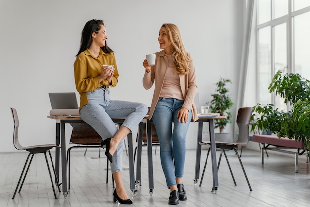 Empresarias hablando mientras disfruta de una taza de café