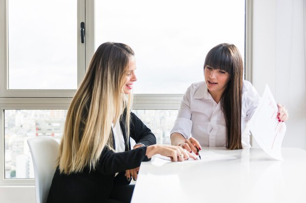 Empresarias que discuten el plan empresarial en el lugar de trabajo en la oficina