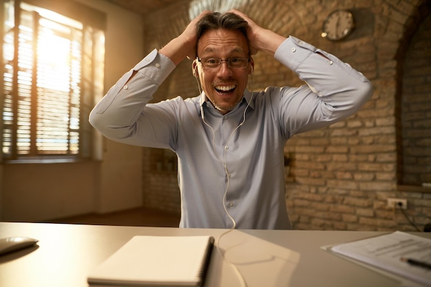 Foto gratuita empresario adulto medio que se siente feliz después de recibir noticias tontas en la oficina