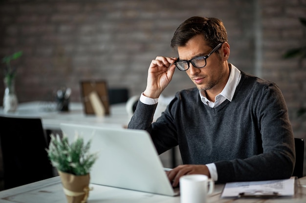 Empresario adulto medio usando computadora mientras trabaja en la oficina