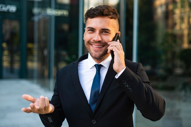 Empresario al aire libre hablando por teléfono con un cliente