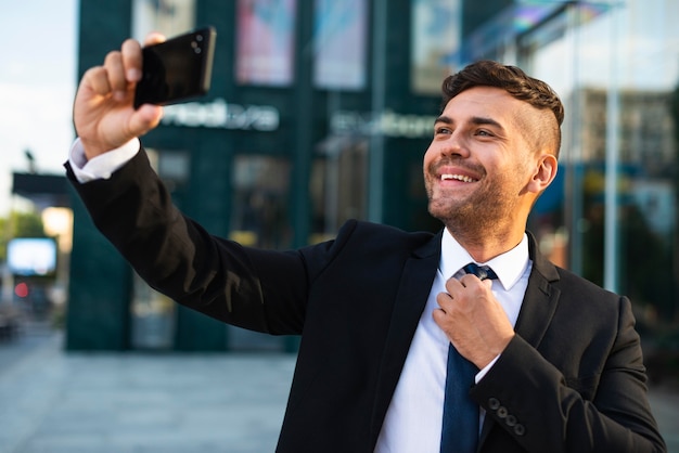 Empresario al aire libre tomando una foto del uno mismo