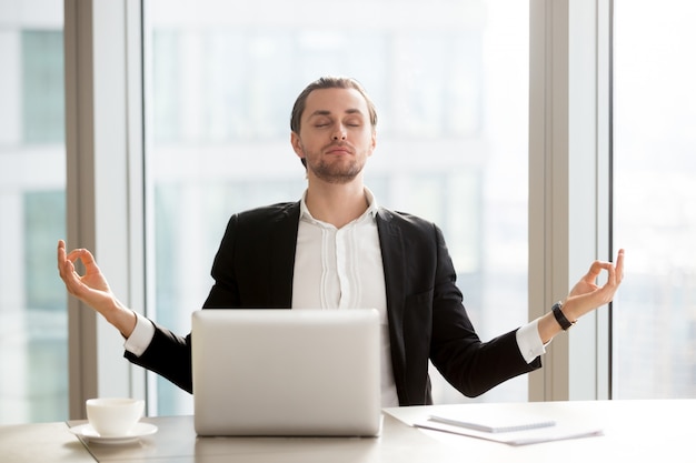 Foto gratuita empresario alivia el estrés laboral con la meditación.