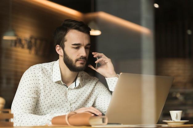 Empresario de bajo ángulo hablando por teléfono