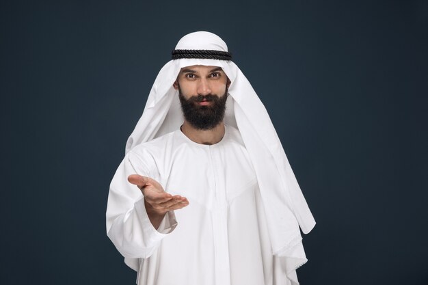 Empresario de Arabia Saudita en la pared azul oscuro