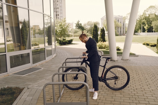 Foto gratuita empresario con bicicleta en una ciudad de verano