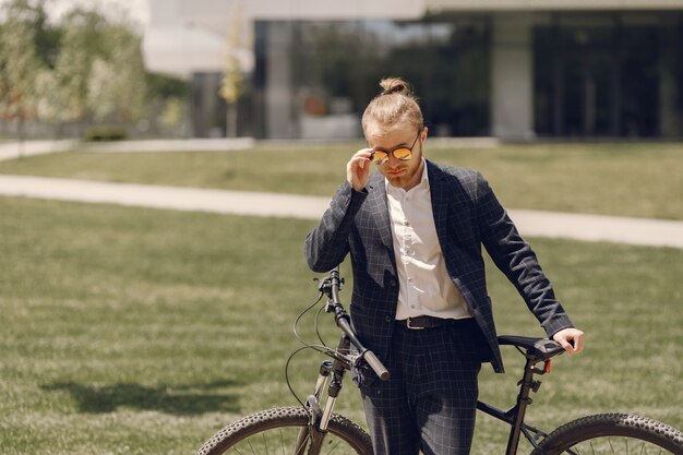 Empresario con bicicleta en una ciudad de verano