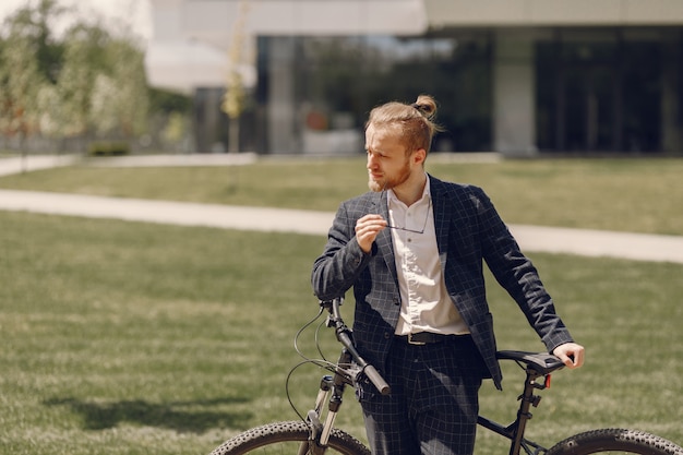 Empresario con bicicleta en una ciudad de verano