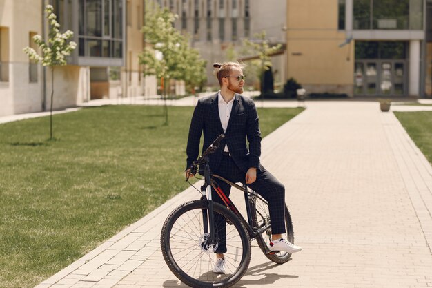 Empresario con bicicleta en una ciudad de verano