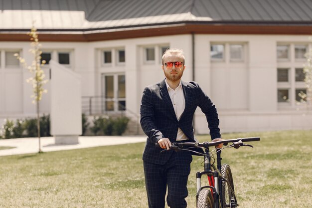 Empresario con bicicleta en una ciudad de verano