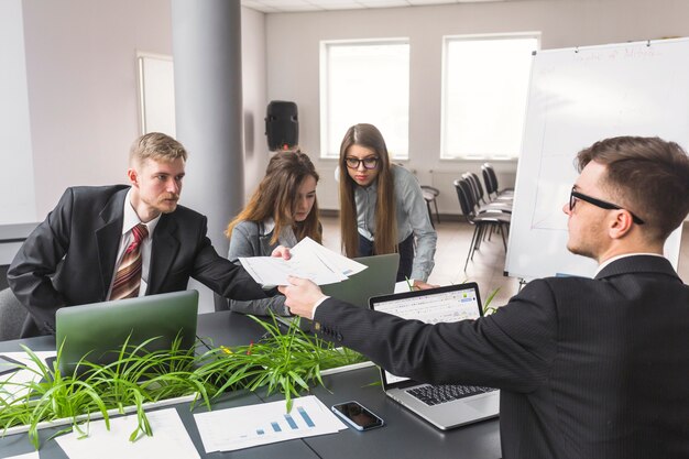 Empresario dando documento a su colega en el lugar de trabajo