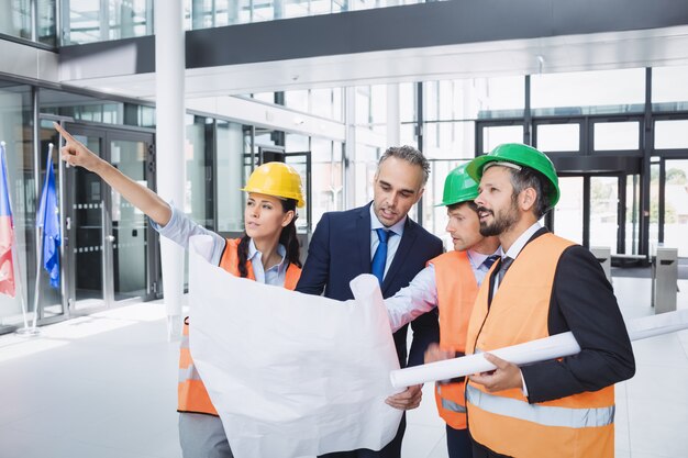 Empresario discutiendo sobre planos con arquitectos