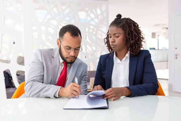 Empresario y empresaria firmando contrato