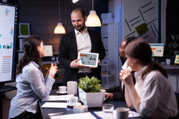 Empresario empresario mostrando la estrategia de la empresa con tableta para presentación corporativa