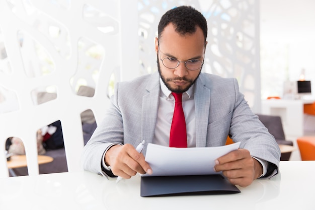 Empresario enfocado leyendo contrato