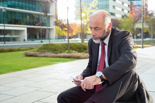 Empresario enfocado mirando papeles