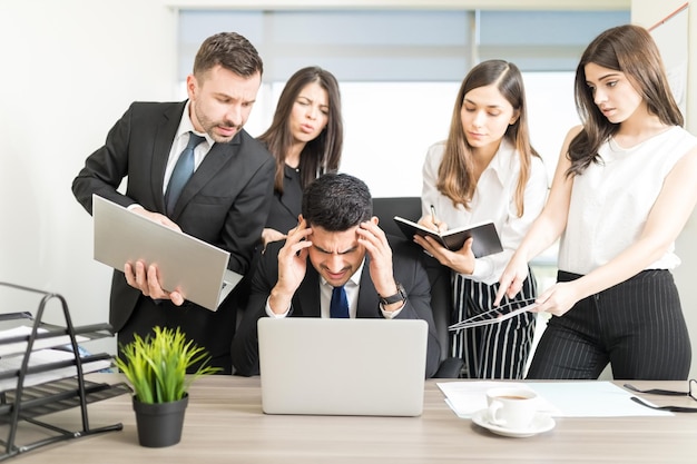 Foto gratuita empresario estresado incapaz de hacer frente a demasiado trabajo asignado por colegas en el cargo