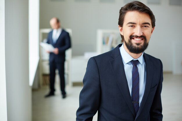 Empresario inteligente con su compañero de equipo en el fondo