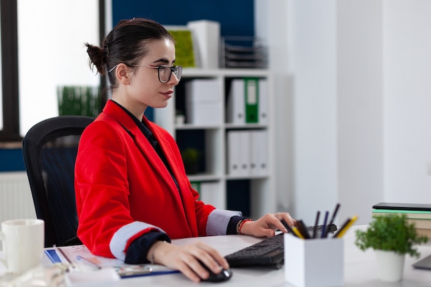 empresario en el lugar de trabajo de la oficina corporativa de negocios trabajando en una computadora portátil con un mouse inalámbrico