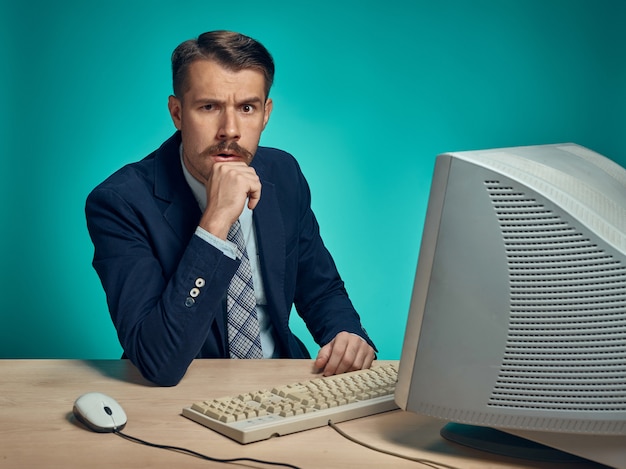 Empresario con mirada sospechosa sentados frente al escritorio frente a la computadora