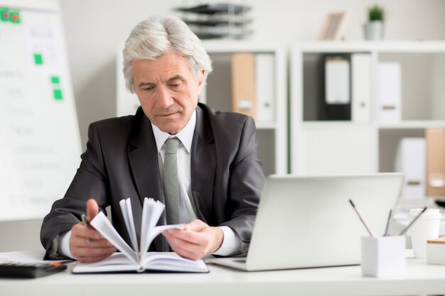 Empresario mirando a través de notas