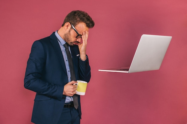 Empresario molesto trabajando en una computadora portátil