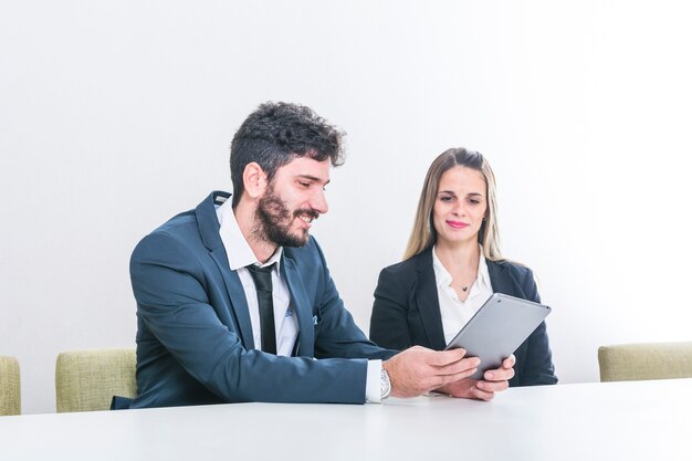 Empresario mostrando tableta digital a su colega