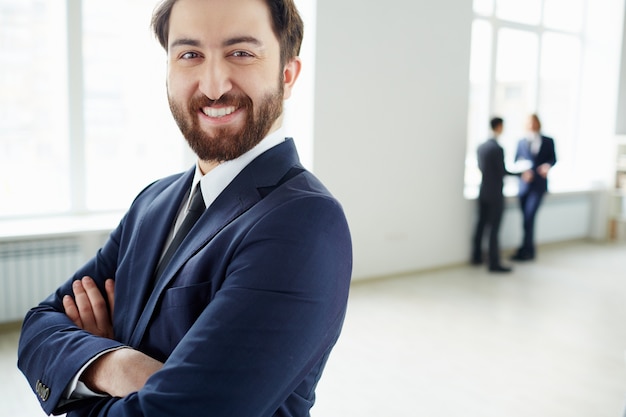 Empresario orgulloso con empleados de fondo