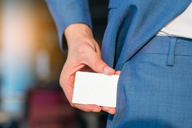 Empresario quitando la tarjeta blanca en blanco de su bolsillo