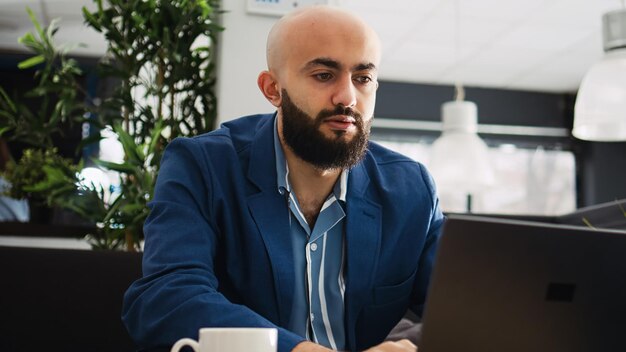 Empresario resolviendo problemas de inicio con portátiles y documentos archivados, mirando el informe anual de estadísticas para encontrar problemas. Analista joven revisando documentos, plan de estrategia ejecutiva.