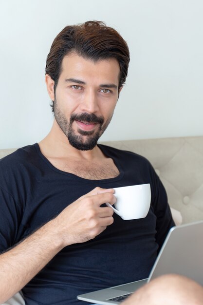 El empresario se siente feliz tomando café durante el trabajo en la oficina en casa