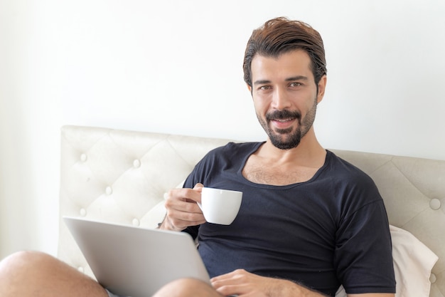 El empresario se siente feliz tomando café durante el trabajo en la oficina en casa