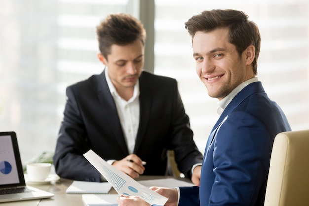 Empresario sonriente, analista financiero o corredor de bolsa buscando un