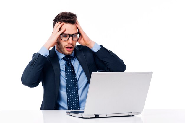 Empresario sorprendido mirando portátil