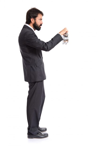 Empresario sosteniendo un reloj sobre fondo blanco